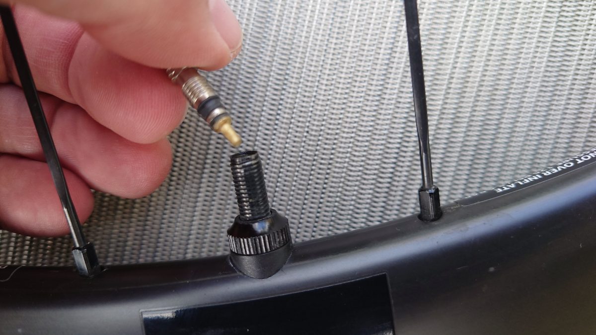 a hand holding a tube with a screwdriver